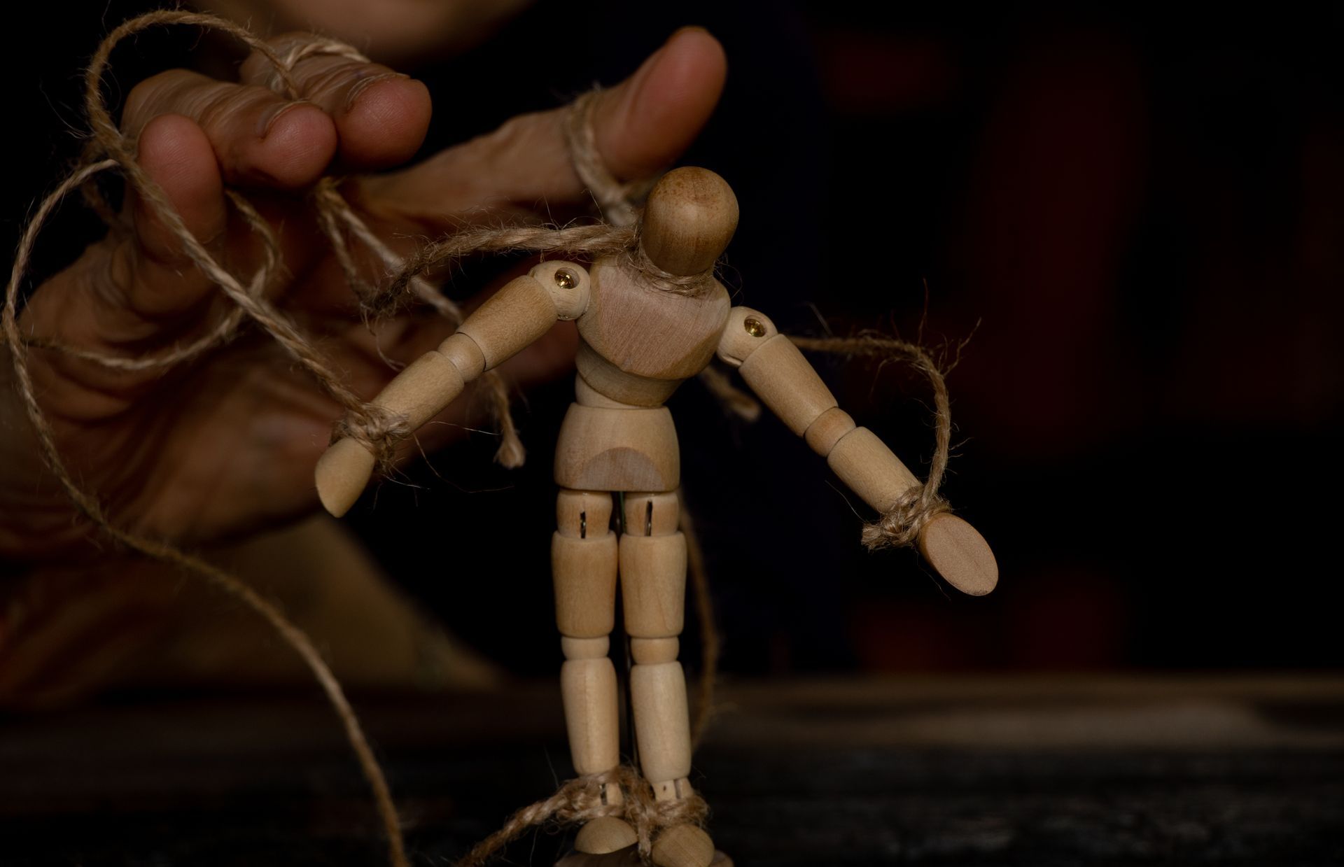 Un homme en bois sur des cordes attachées à la main d'un homme - Sonia Bahouth psychologue, Cabinet Sagita