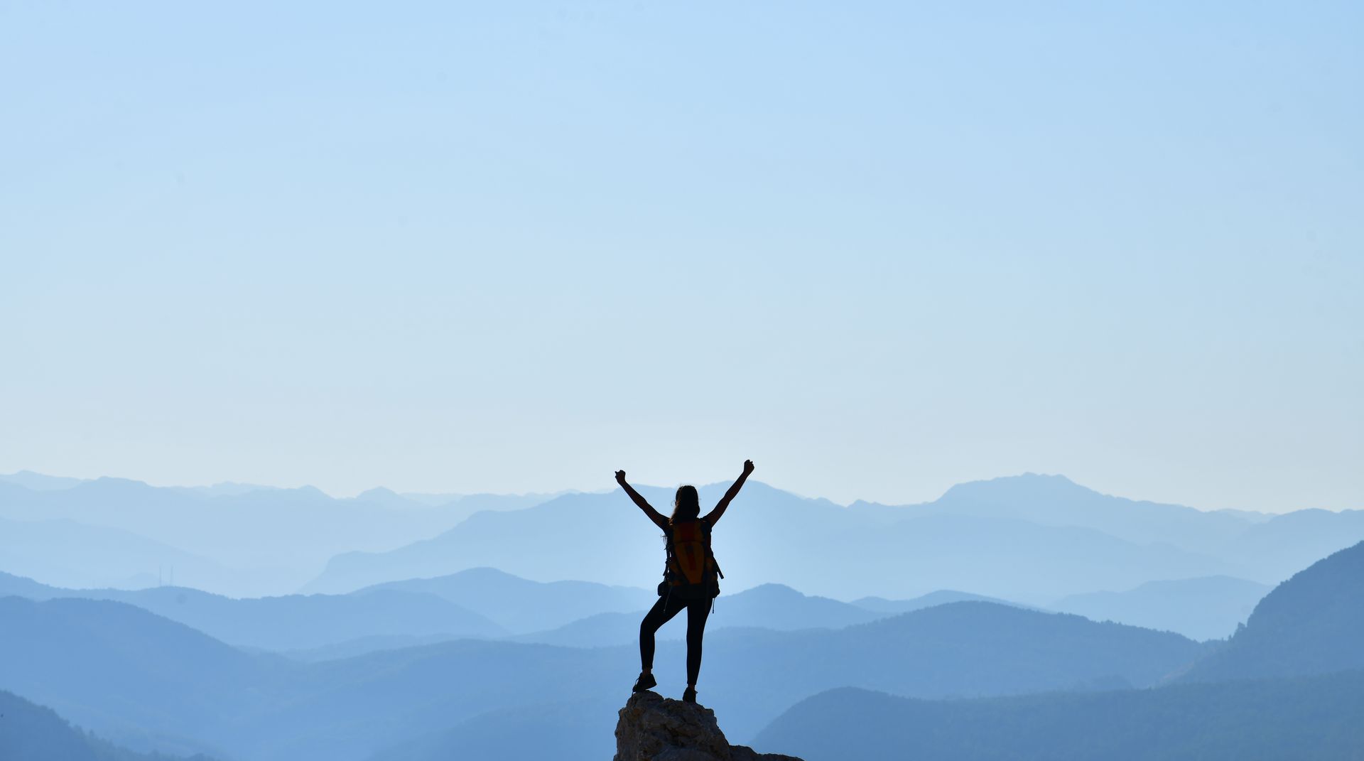 Personne au sommet d'une montagne avec les bras levés en signe de réussite - Sonia Bahouth psychologue, Cabinet Sagita