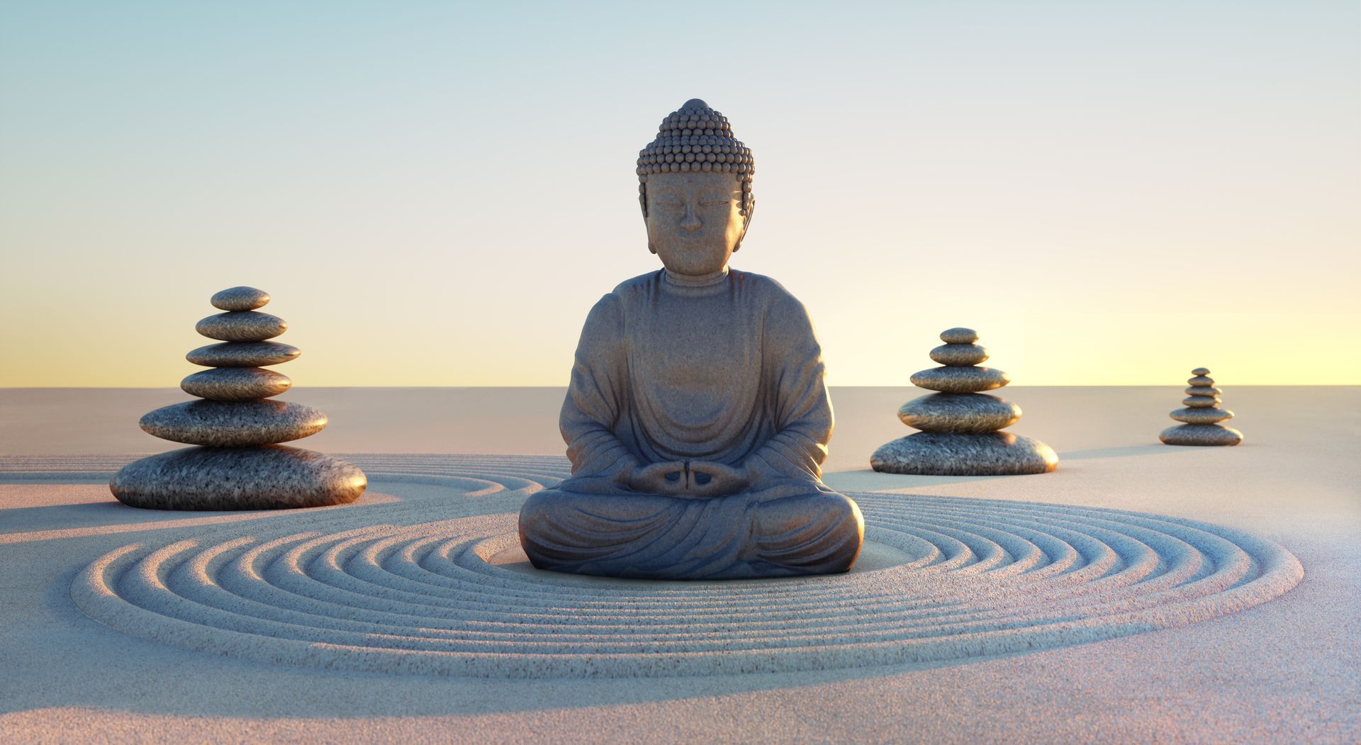 Statue de Bouddha et galets empilés dans le sable pour une ambiance zen - Sonia Bahouth psychologue, Cabinet Sagita
