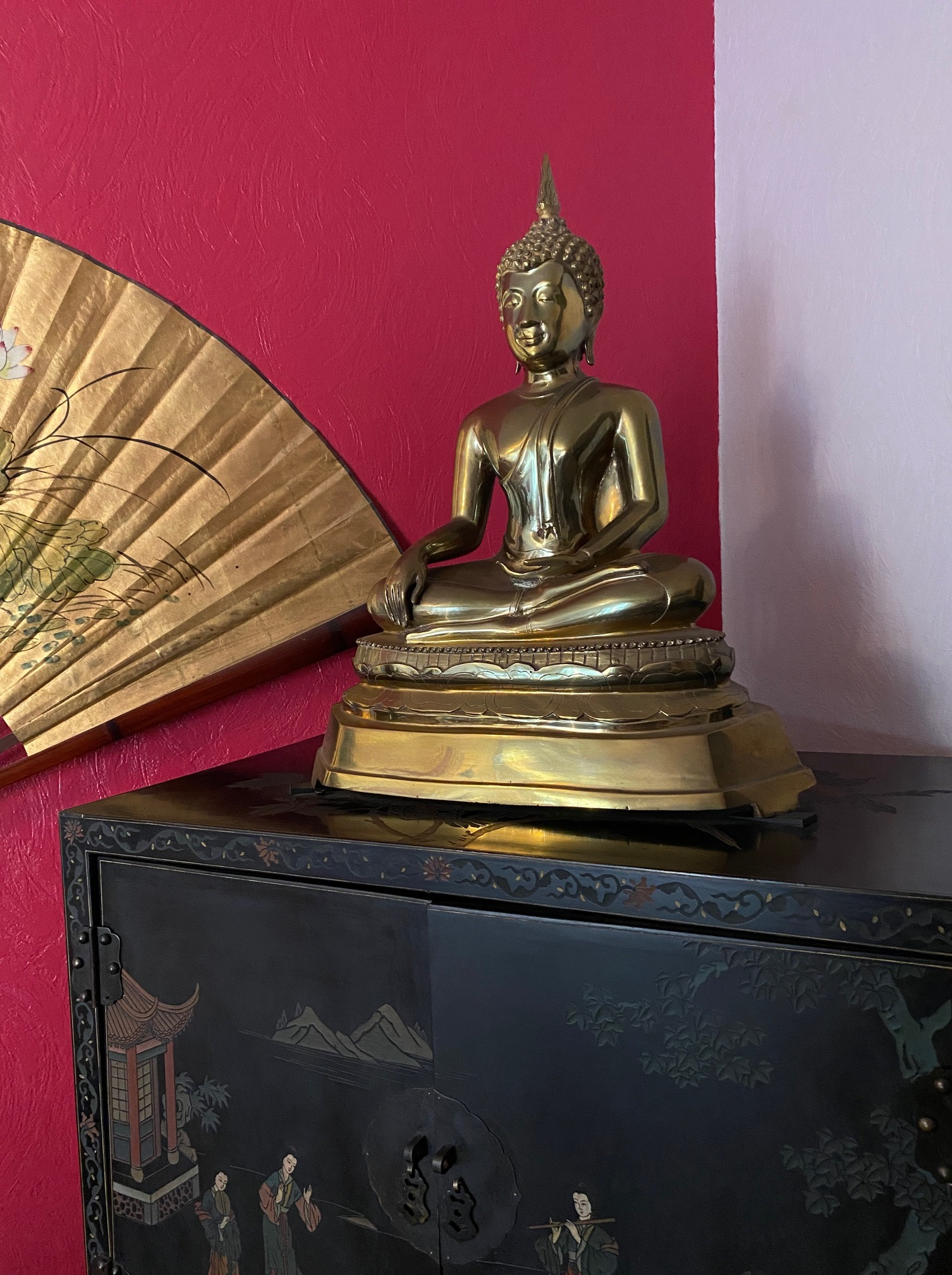 Bouddha doré placé sur un meuble laqué et éventail accroché sur un mur - Cabinet Sagita à Dijon