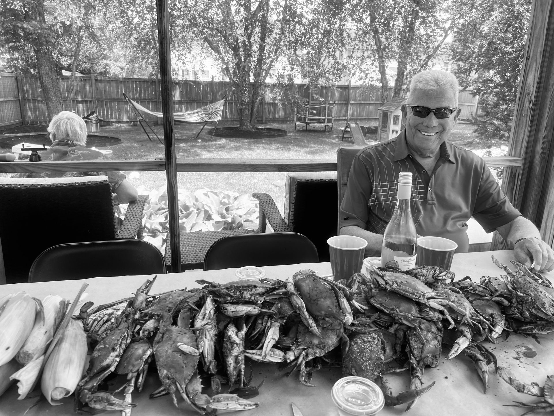 Two people paddleboarding on a calm ocean; one raises paddle overhead.
