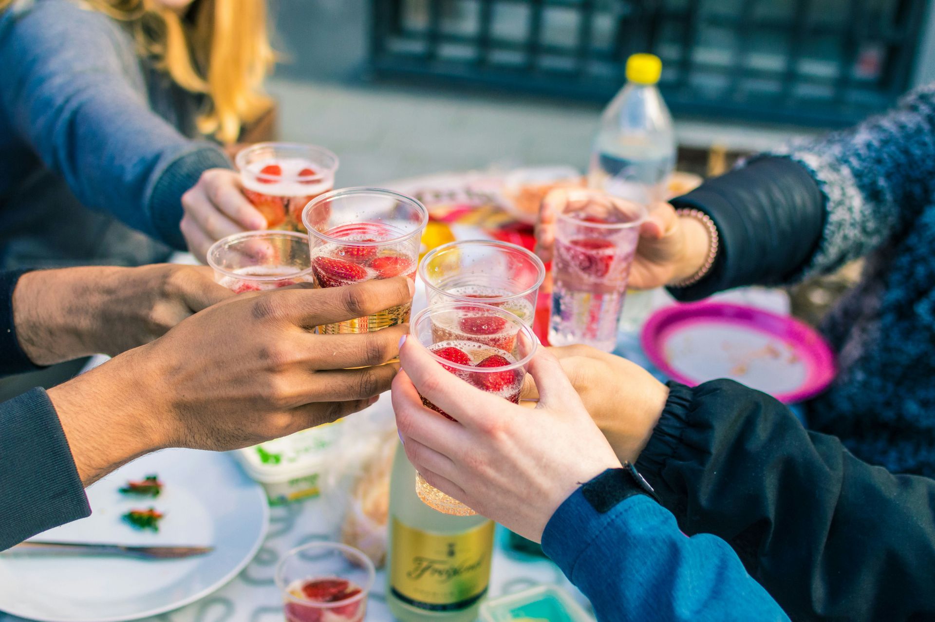 A group of people are toasting with wine glasses at a table.