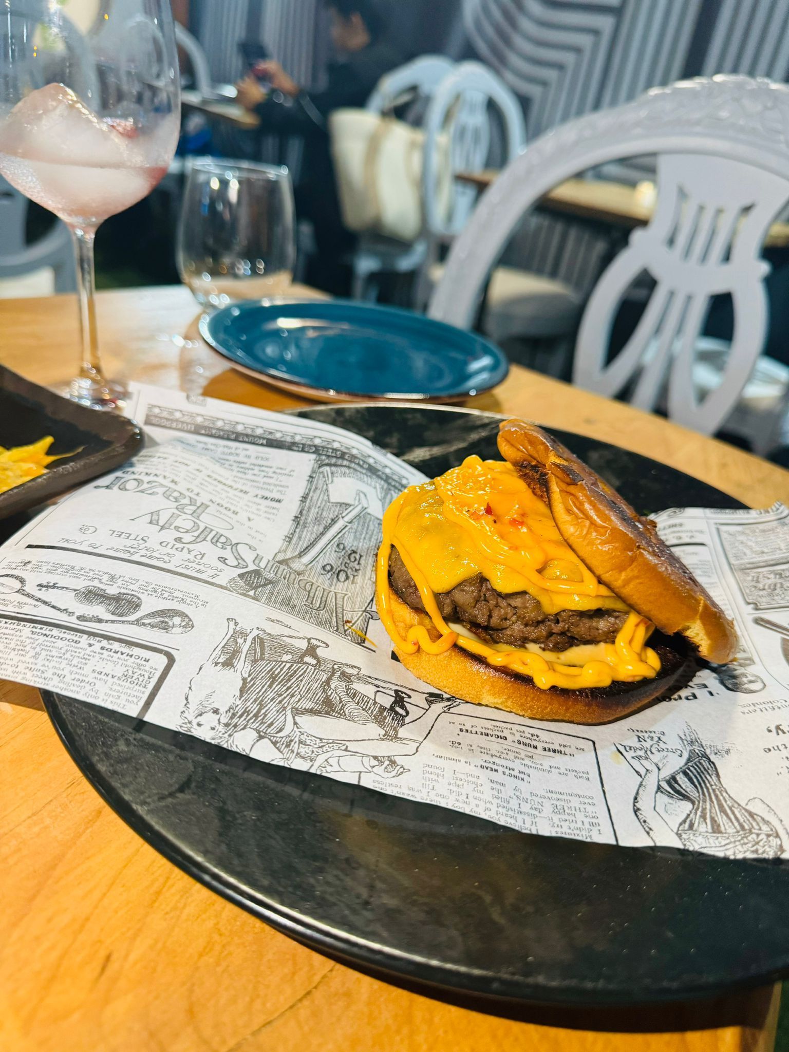 Una hamburguesa está sentada en un plato sobre una mesa.