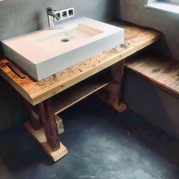 Ein Waschbecken steht auf einer Holzablage.