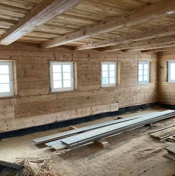 Ein Holzraum mit vielen Holzbalken und Fenstern.