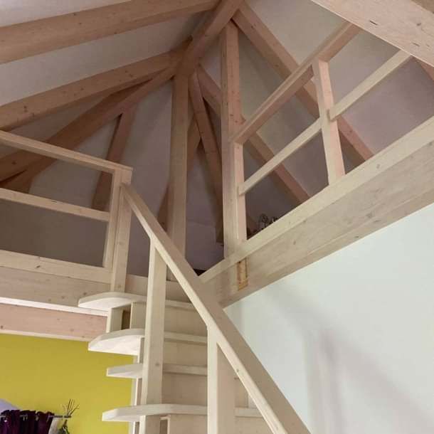 Eine Holztreppe in einem Raum mit einer gelben Wand