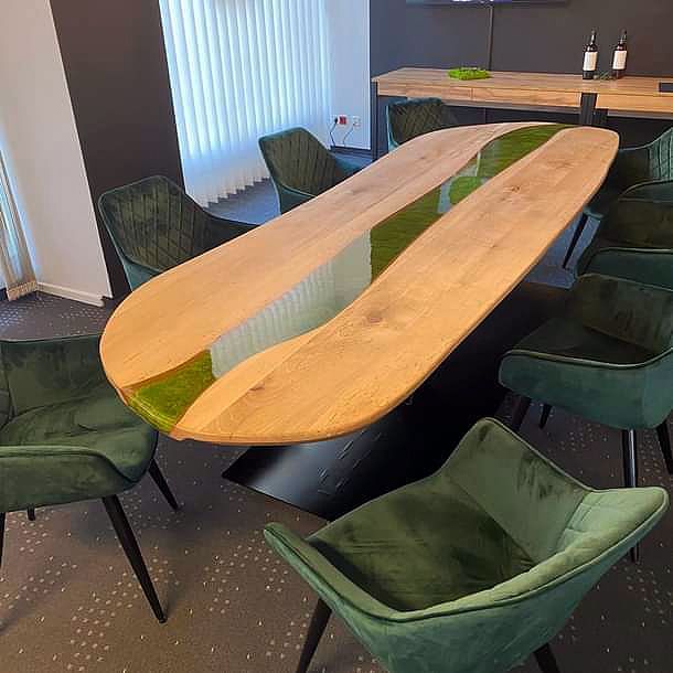 Ein Holztisch mit grünen Stühlen in einem Zimmer.