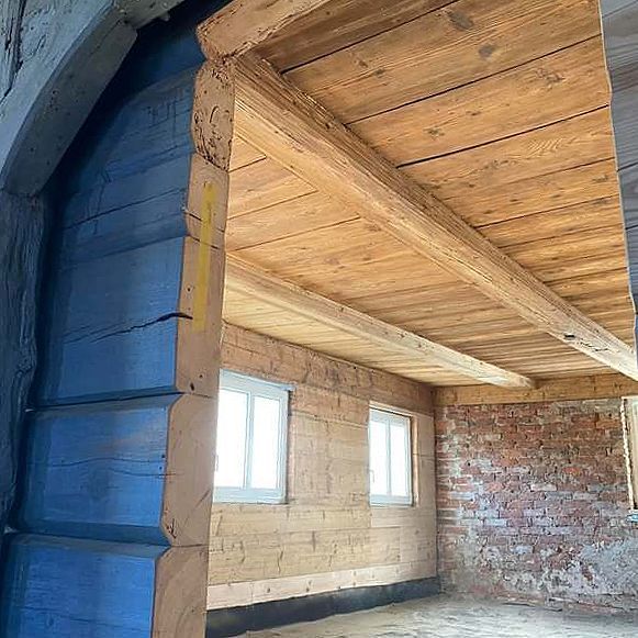 Ein Raum mit Holzdecke und Ziegelwänden.