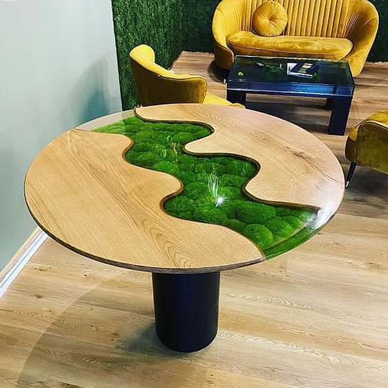 Ein Holztisch mit einem Fluss aus Moos darauf in einem Wohnzimmer.