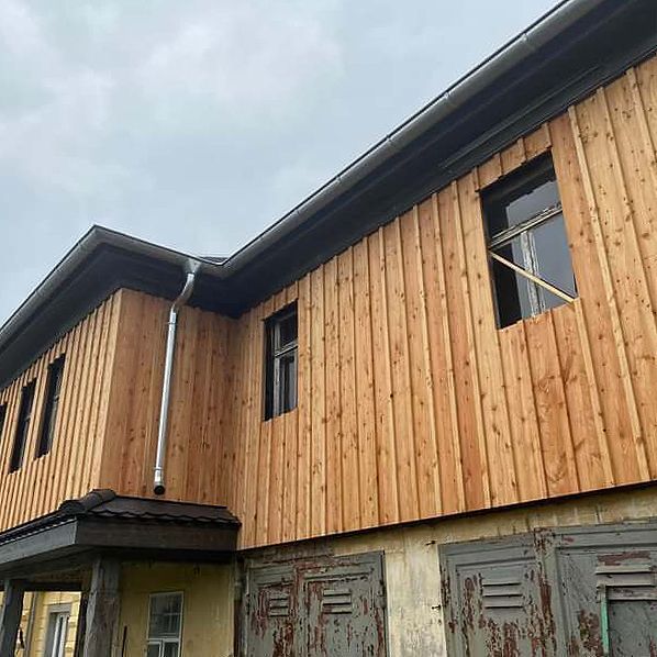 Ein großes Holzgebäude mit vielen Fenstern und Fensterläden.