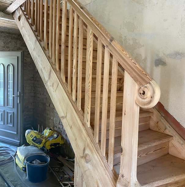 Eine Holztreppe mit einem Holzgeländer in einem Raum.