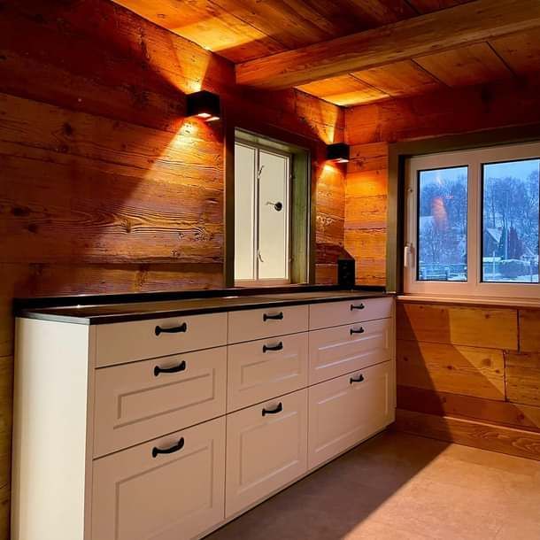 Eine Küche mit weißen Schränken und einem Fenster.