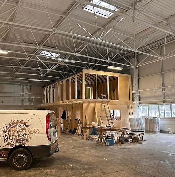 Ein weißer Lieferwagen steht in einer großen Lagerhalle.