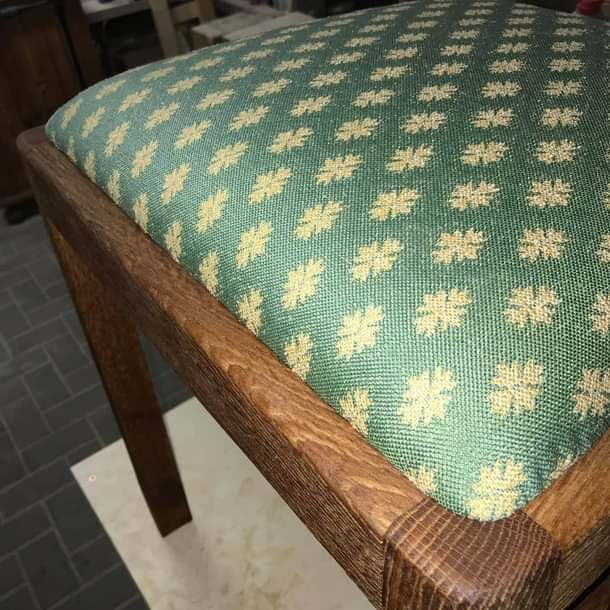 Ein Holzhocker mit einem grün-gelben Muster darauf