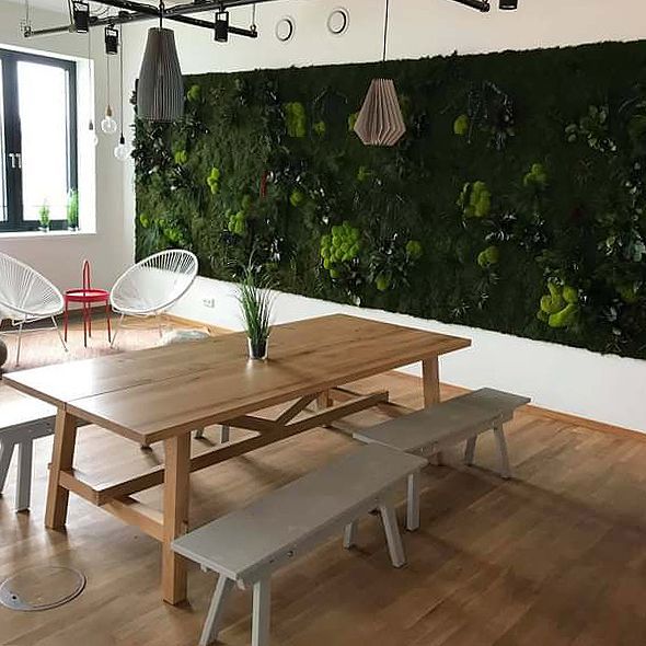 Ein Esszimmer mit einem Holztisch und Bänken und einer grünen Wand.