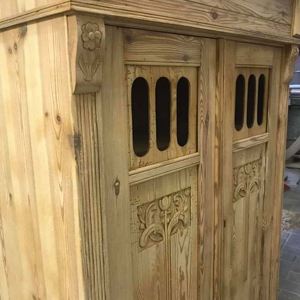 Eine Nahaufnahme eines Holzschranks mit einem geschnitzten Muster auf den Türen.