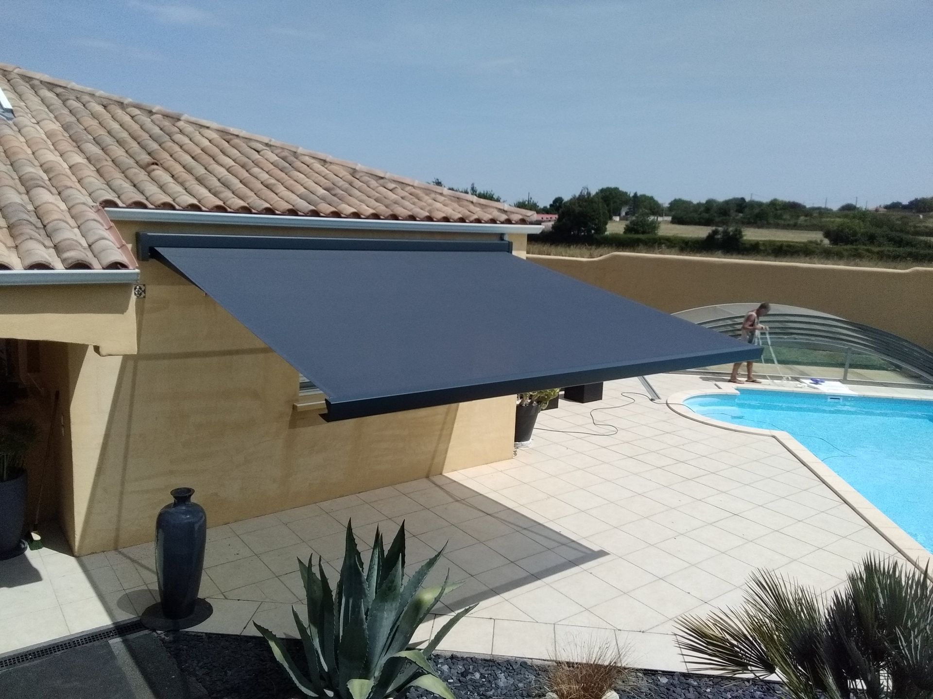 Store banne gris près d'une piscine