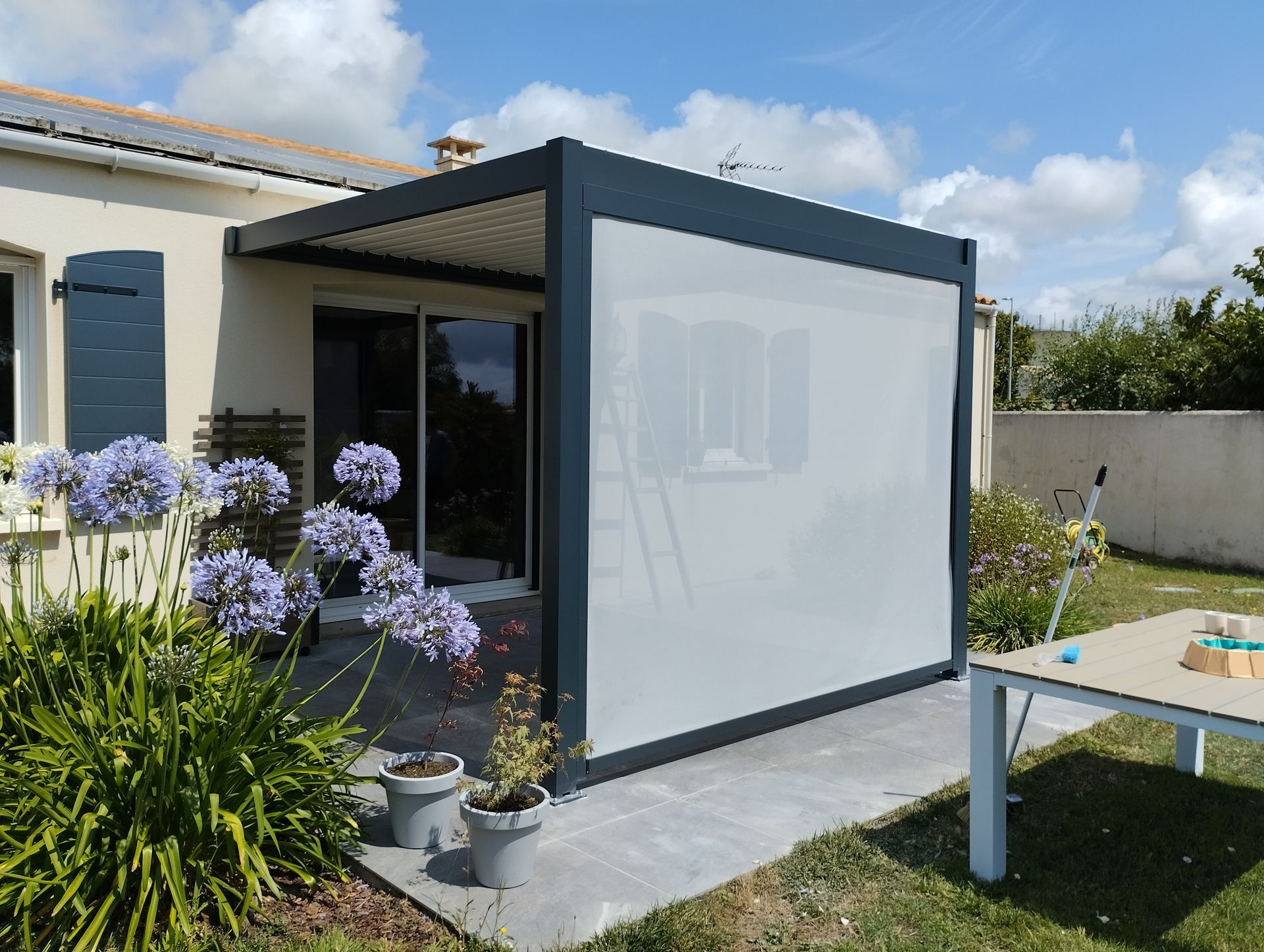 Une pergola en aluminium avec une toile tendue