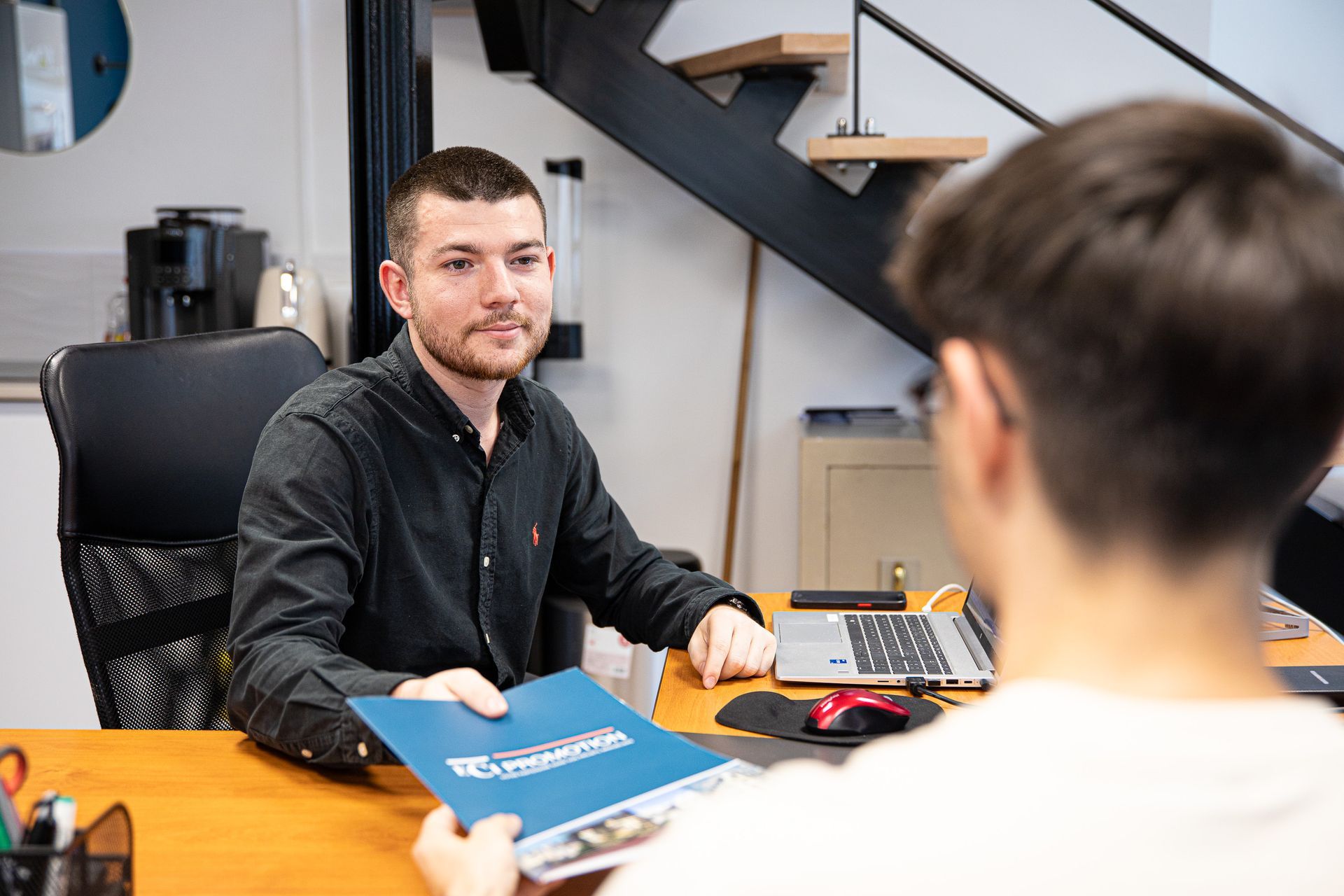 Un homme donne un document à une personne