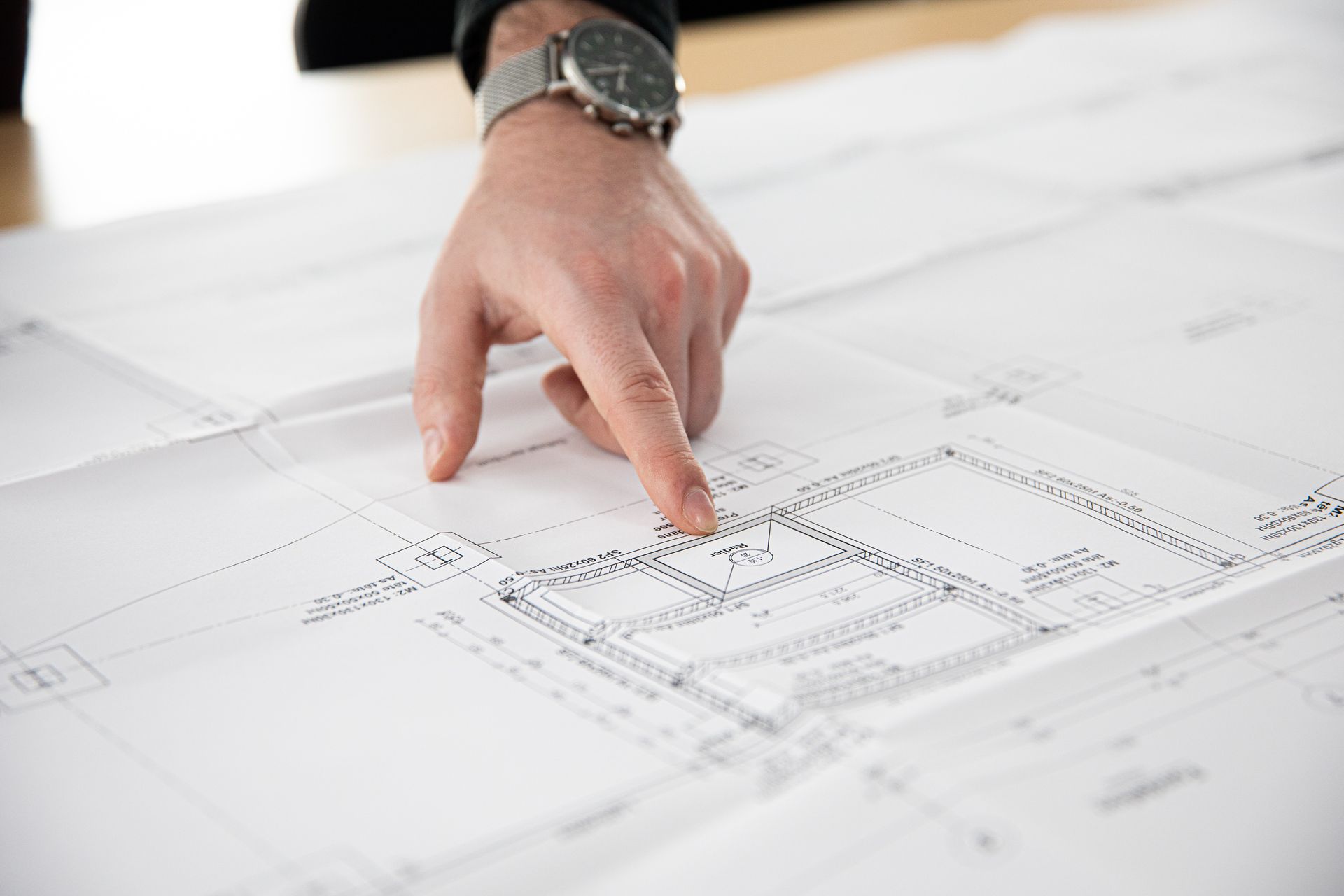Une main sur des plans d'architecte