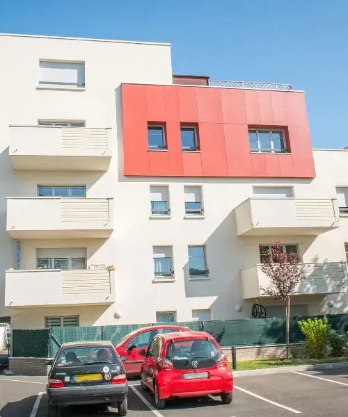 Un immeuble blanc et rouge avec voitures