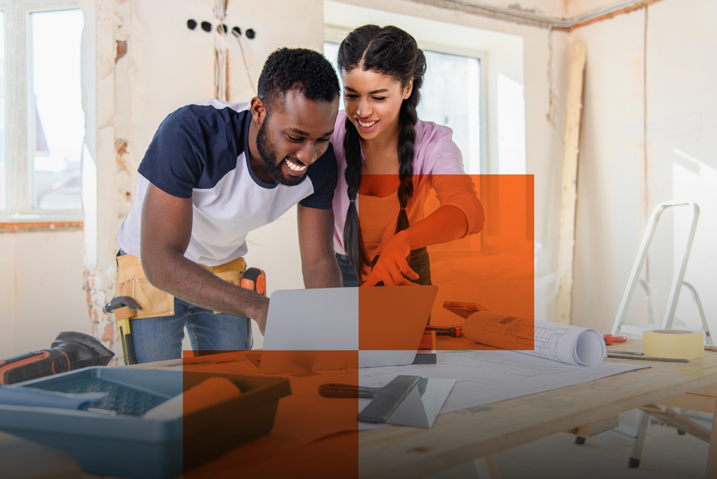 Un homme et une femme devant un écran dans une pièce en travaux
