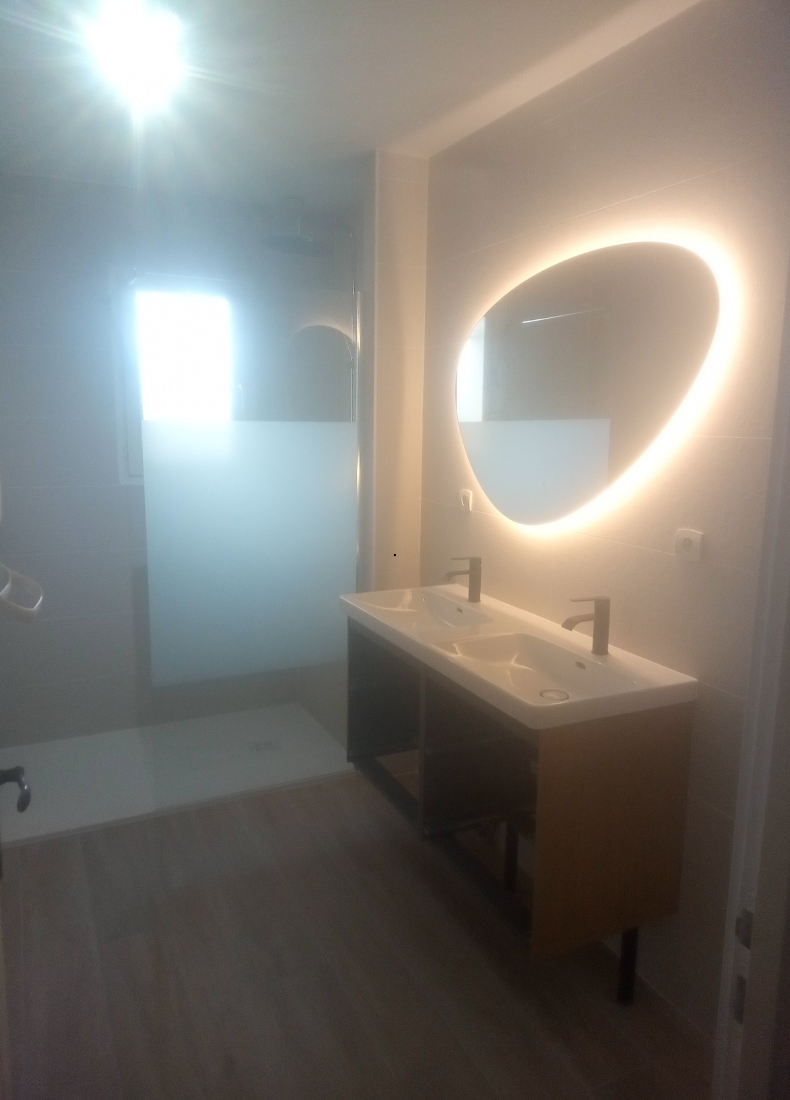 Une salle de bain avec deux lavabos et un grand miroir