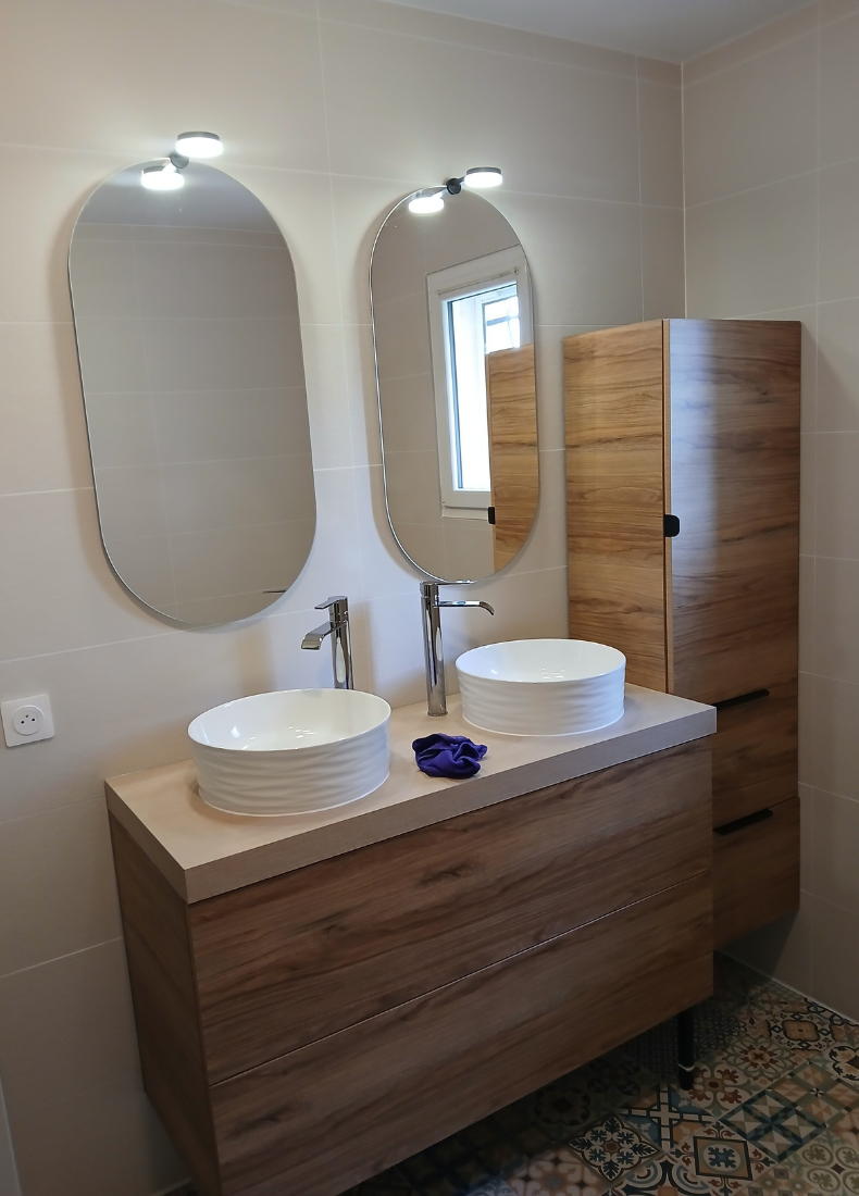 Une salle de bain avec deux lavabos et deux miroirs.