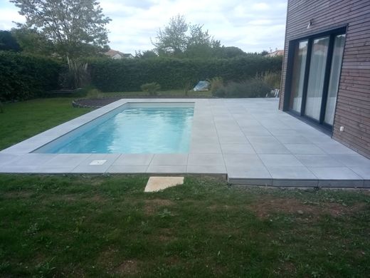 Une grande piscine se trouve dans l'arrière-cour d'une maison.