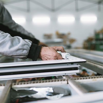 Un homme travaille sur un morceau de métal dans une usine.