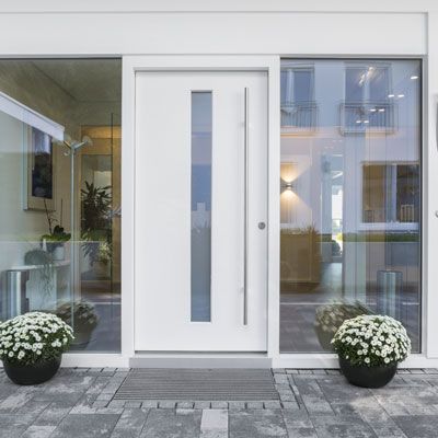 Une porte blanche avec des fleurs devant