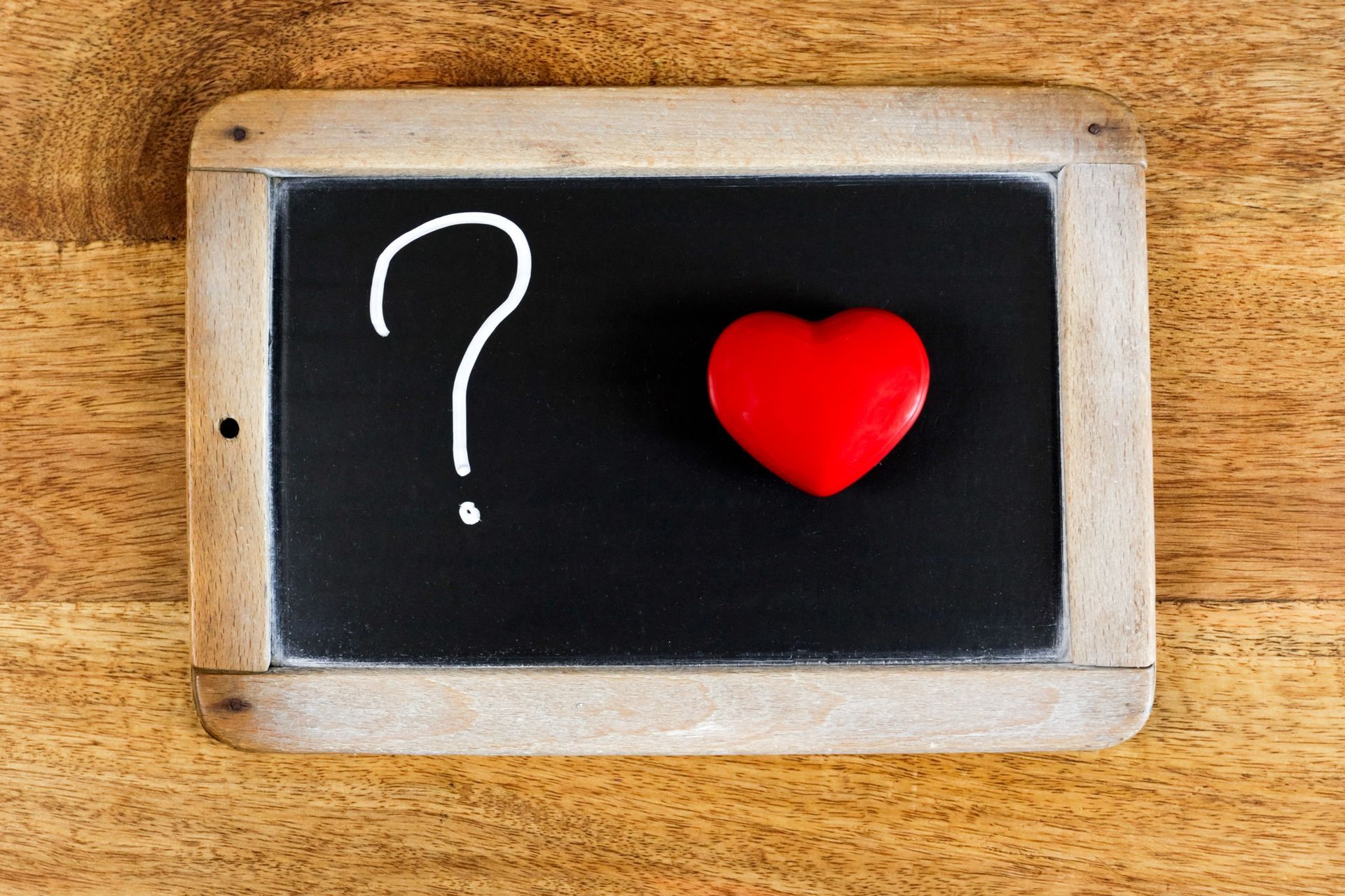 Ardoise, point d'interrogation et figurine en forme de coeur.