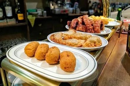 Platos de aperitivos fritos variados en una mesa de bufé en un bar o restaurante.