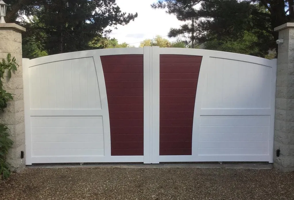 Portail blanc fermé en PVC avec deux bandes bordeaux au milieu