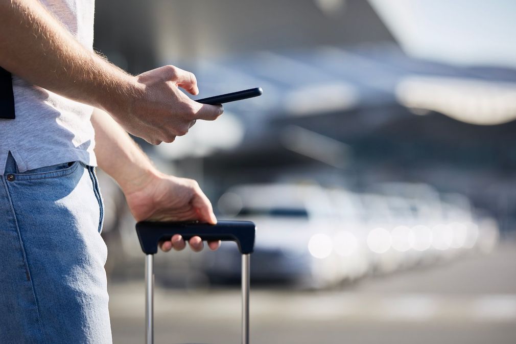 Personne en train de tenir un téléphone et une valise