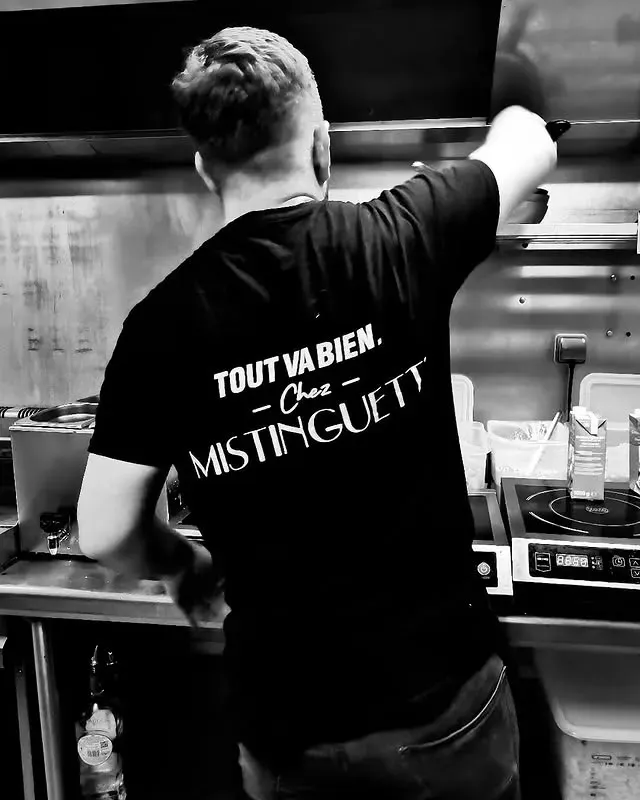 Cuisinier de dos, dans sa cuisine.