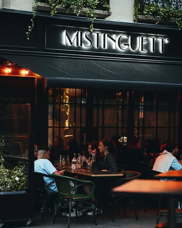 Extérieur du restaurant, auvent noir, terrasse avec des clients attablés, vue sur la rue.