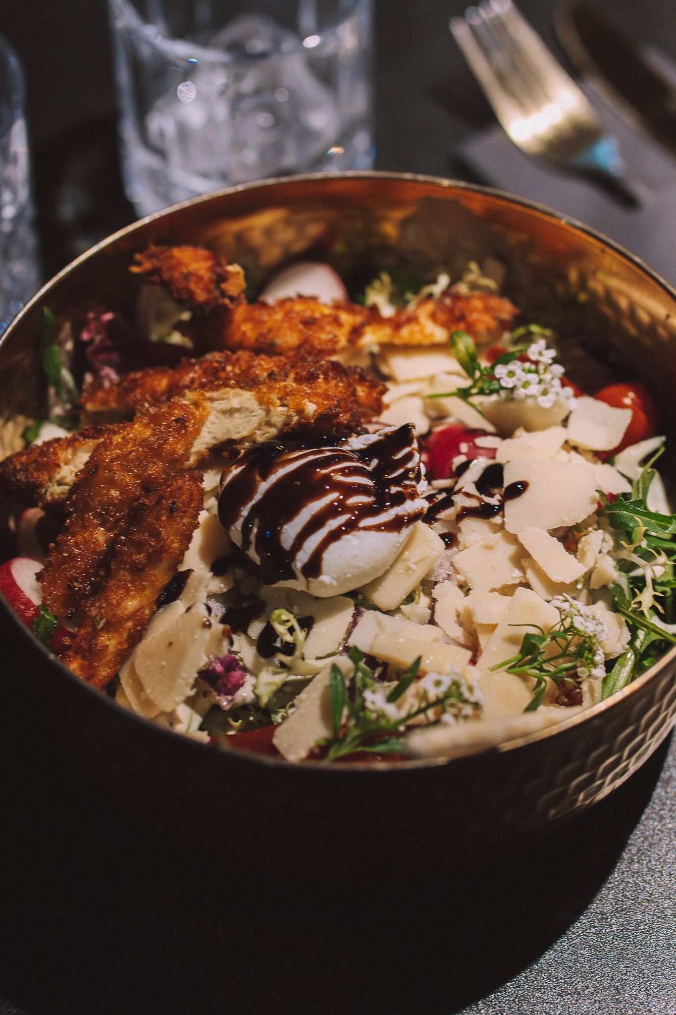 Salade composée de poulet frit, tomates, parmesan et réduction balsamique.