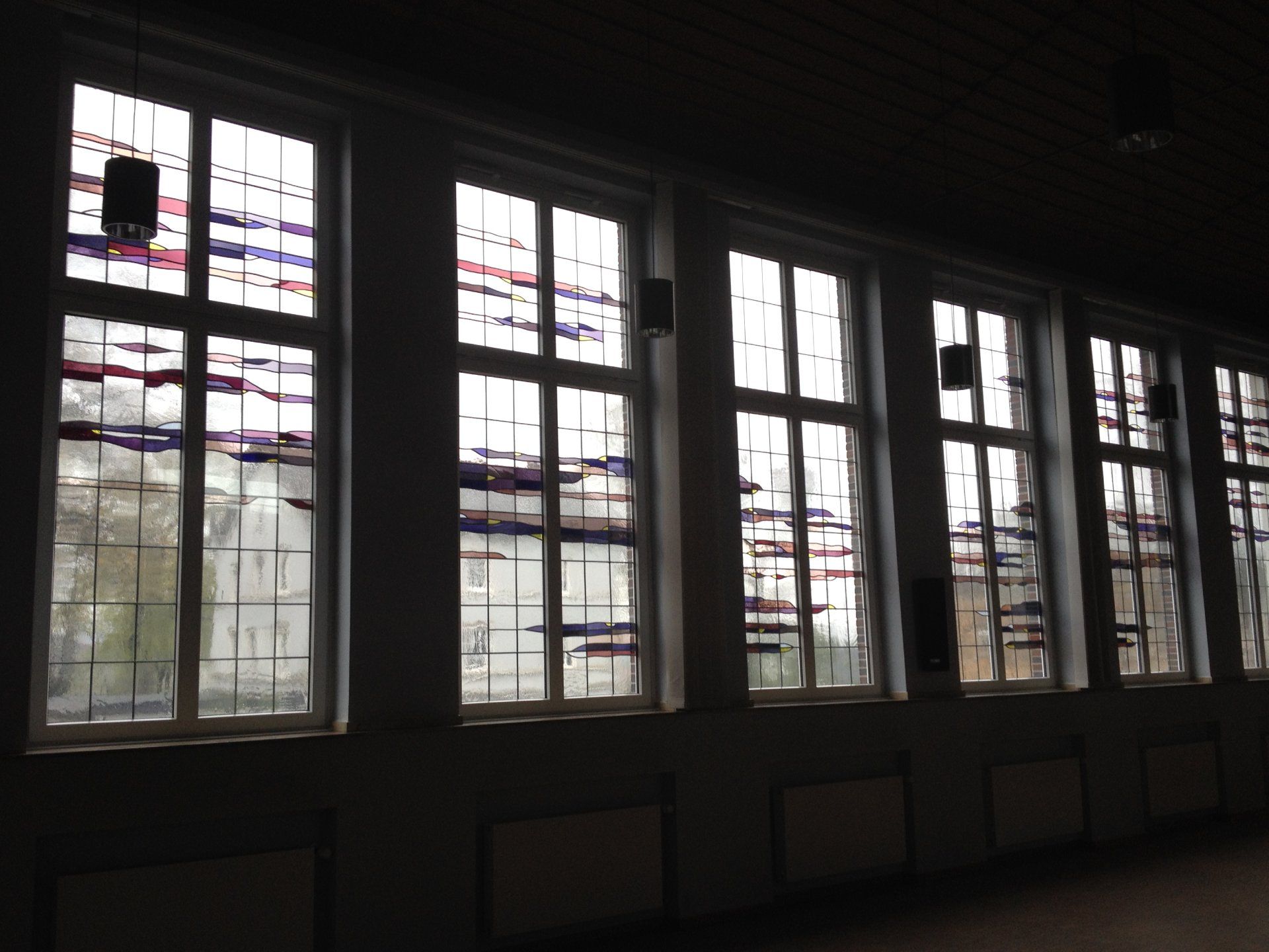 Eine Reihe von Buntglasfenstern in einem dunklen Raum