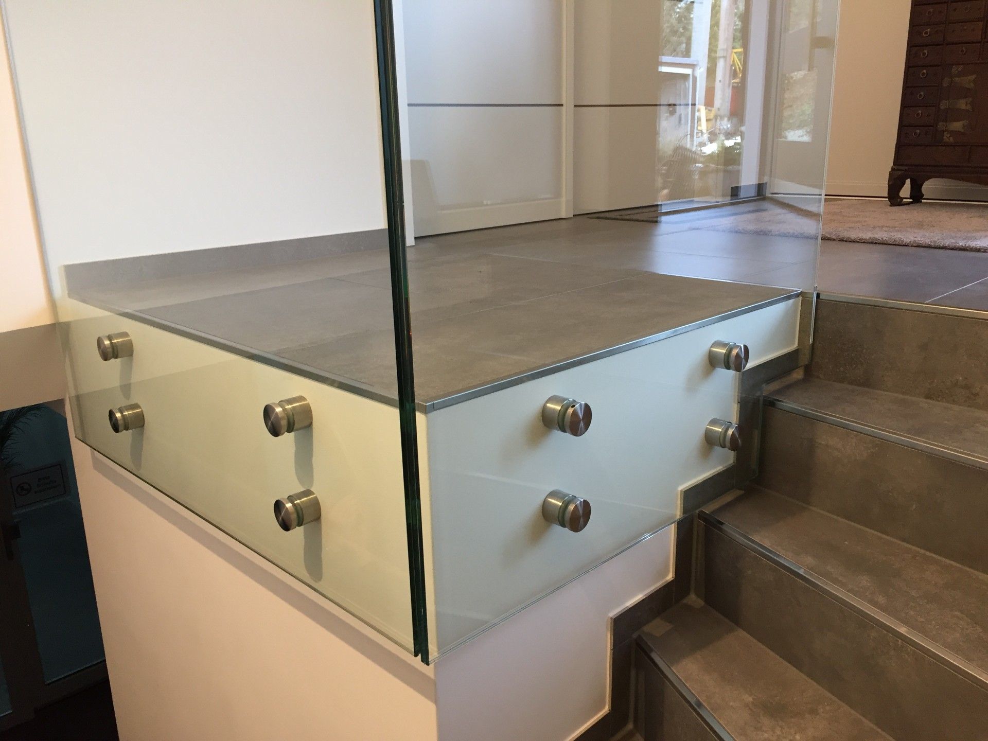 Eine Nahaufnahme eines Glasgeländers an einer Treppe.