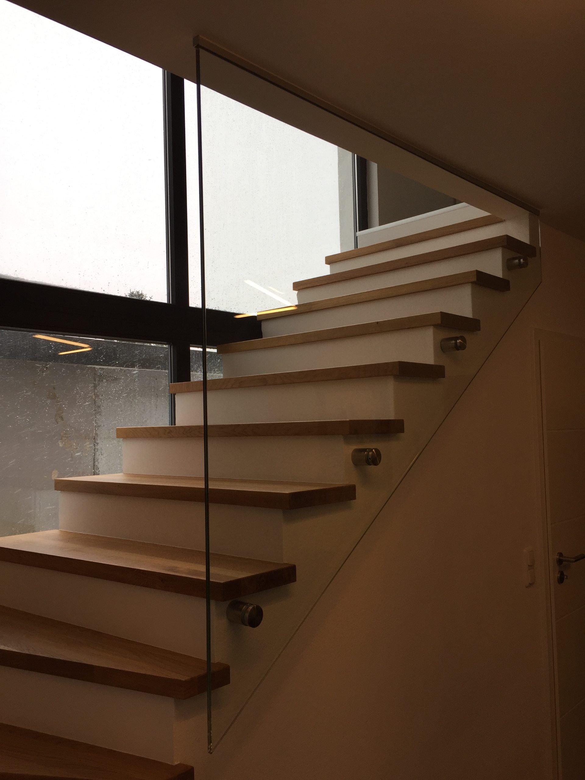 Eine Treppe mit Holzstufen und einem Glasgeländer