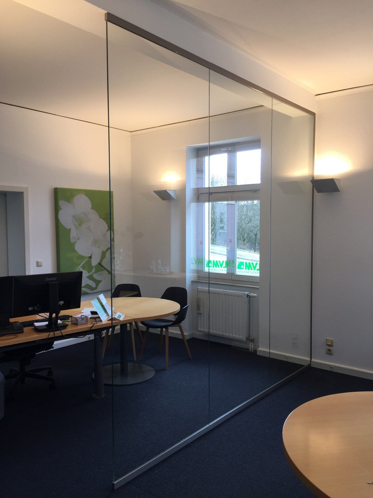 Ein Konferenzraum mit einer Glaswand und einem Tisch und Stühlen