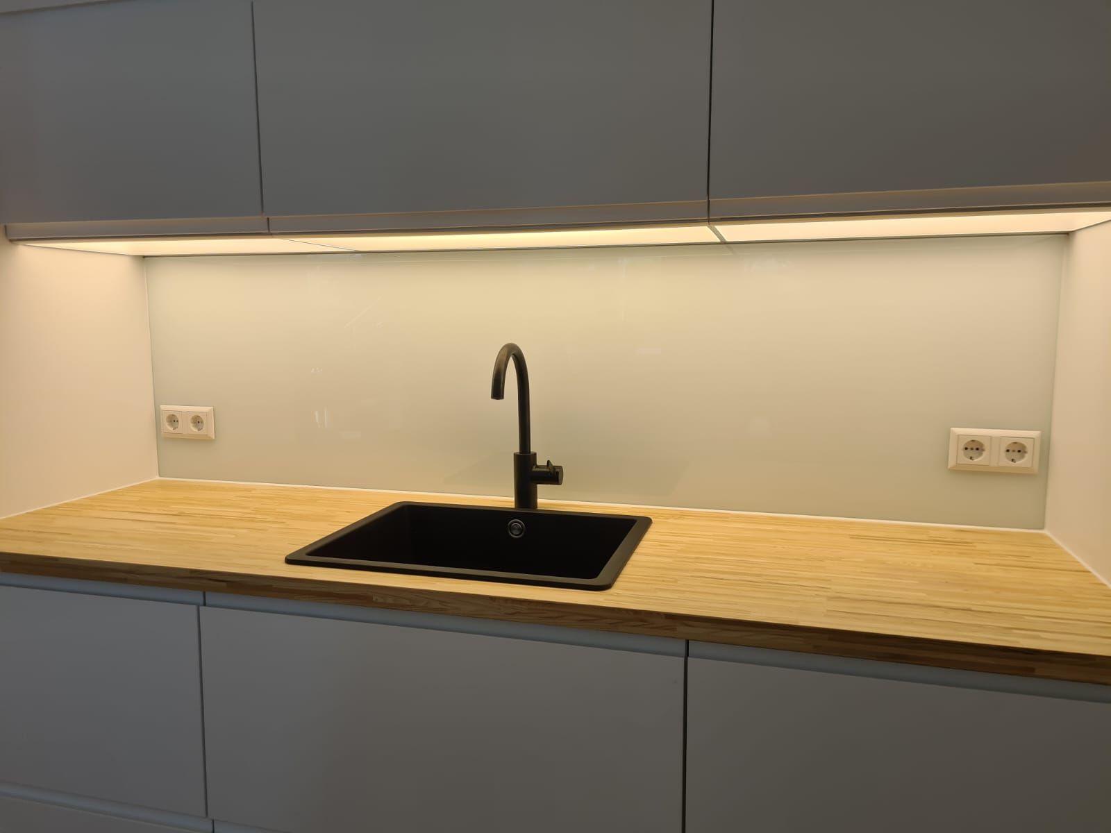 Eine Küche mit Spüle und Holzarbeitsplatte