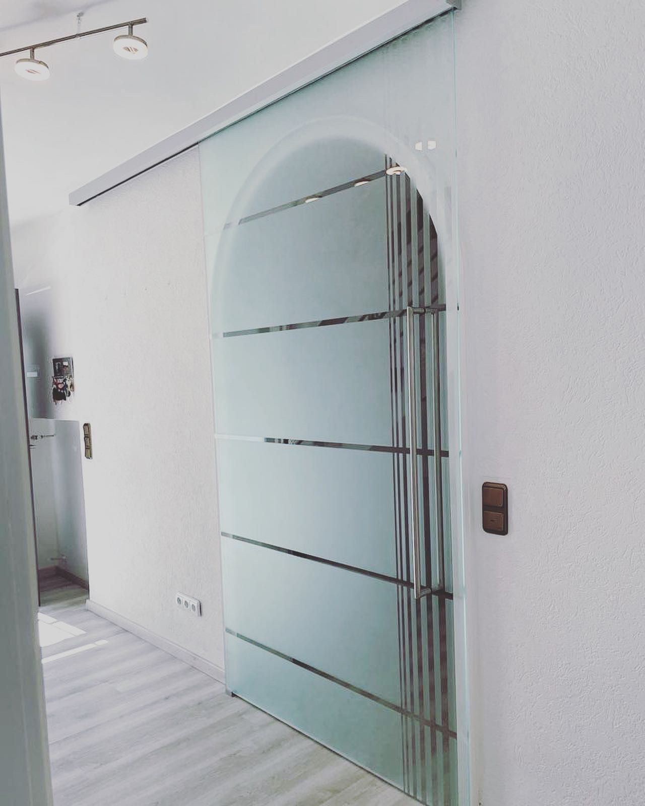 Ein weißer Flur mit einer Glasschiebetür