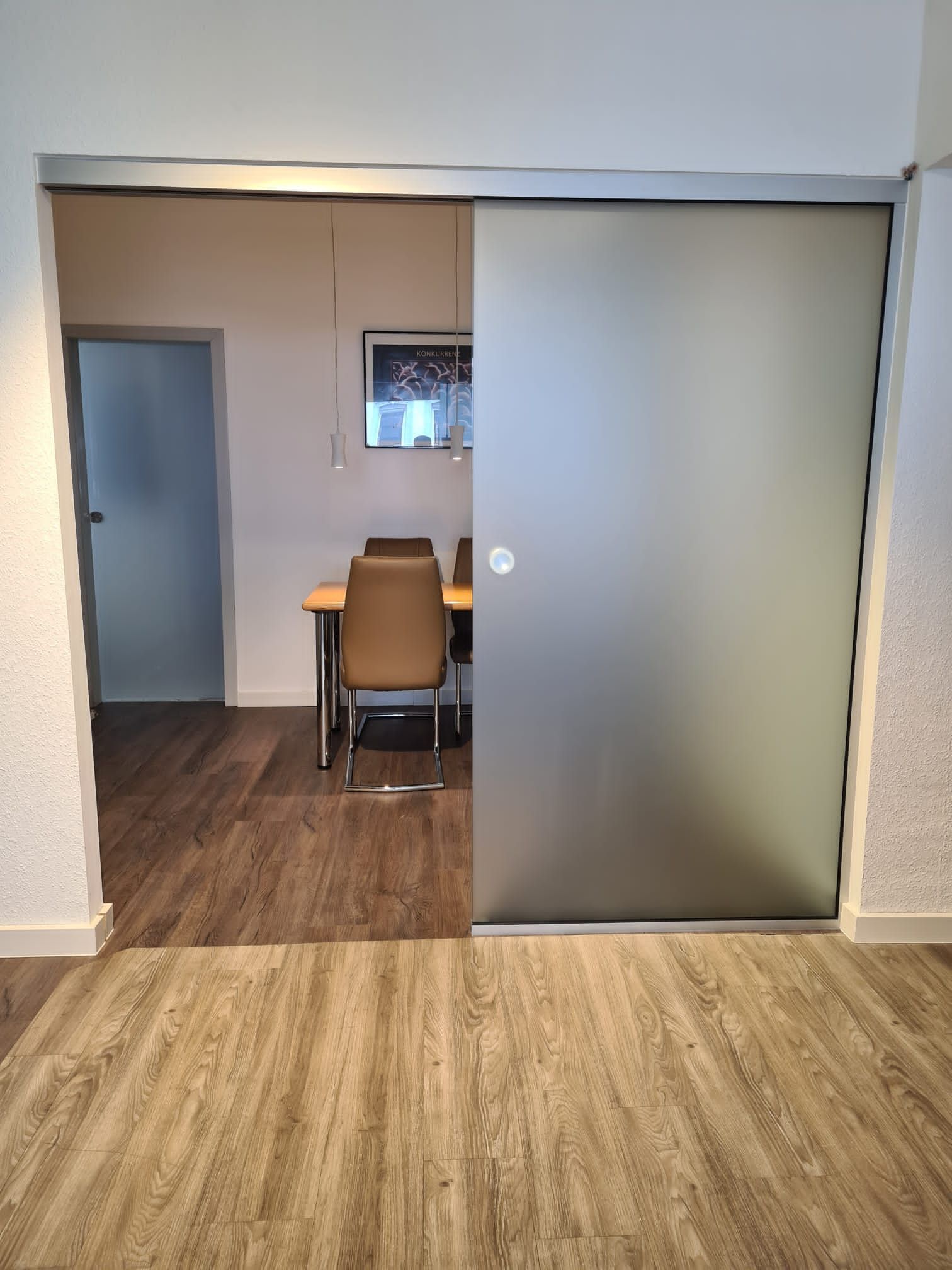 Eine Glasschiebetür zwischen Wohnzimmer und Esszimmer.