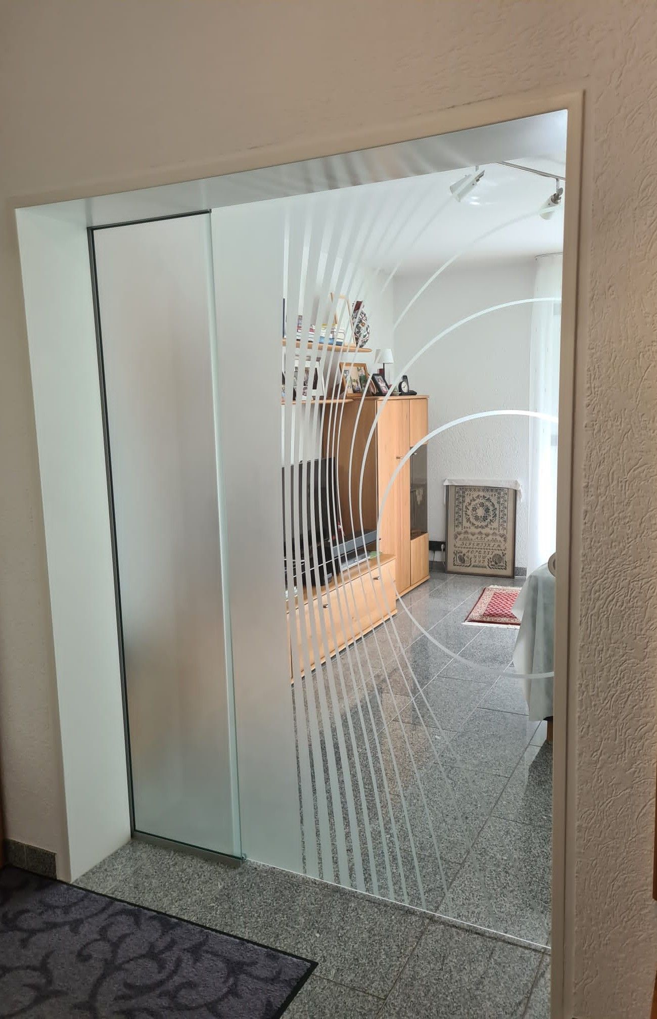 Ein Raum mit einer Glasschiebetür, die zum Wohnzimmer führt.