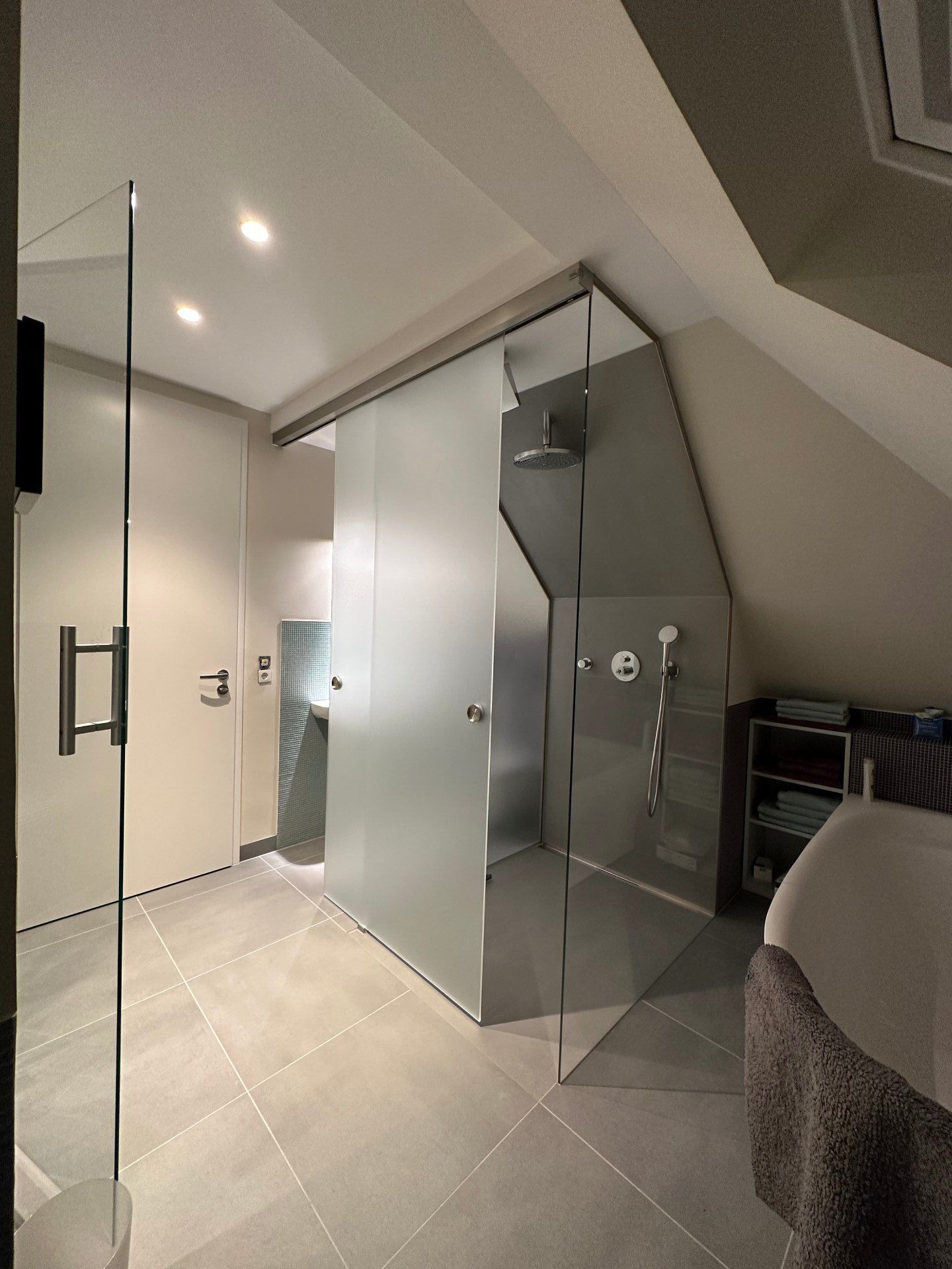 Ein Badezimmer mit Glasschiebetüren und einer Badewanne