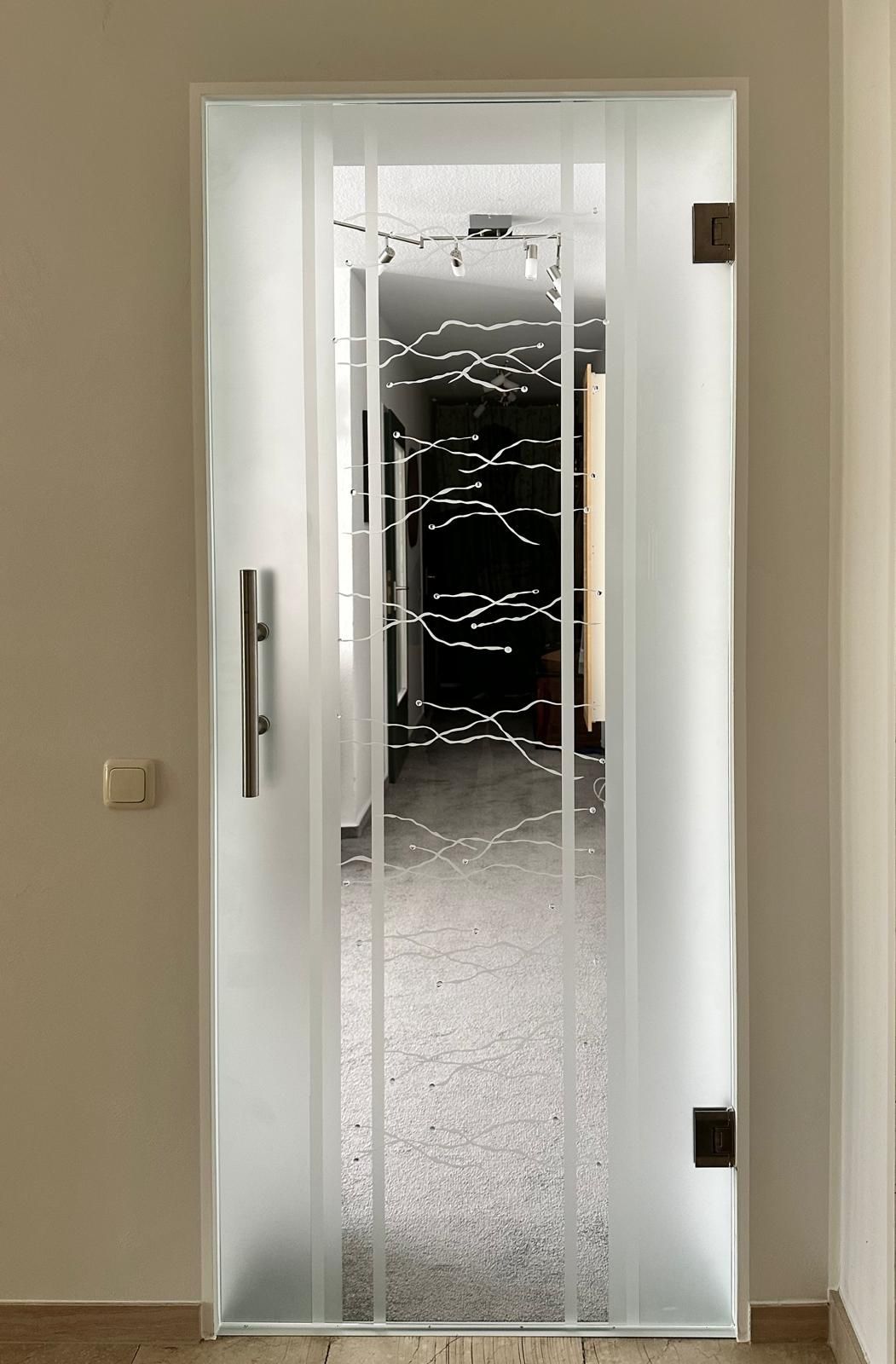 Eine Tür mit einem Design darauf ist zu einem Flur hin offen