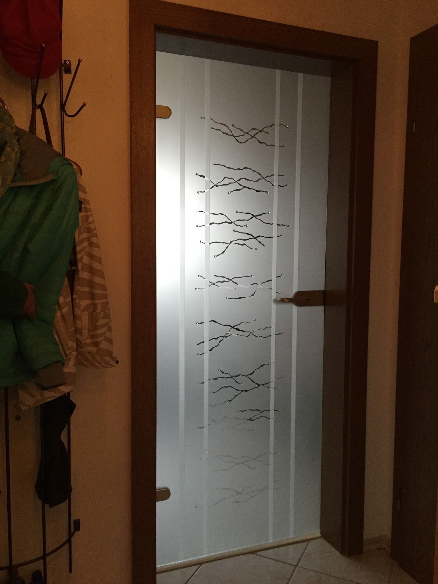 In einem Flur befindet sich eine Tür mit einem Muster.