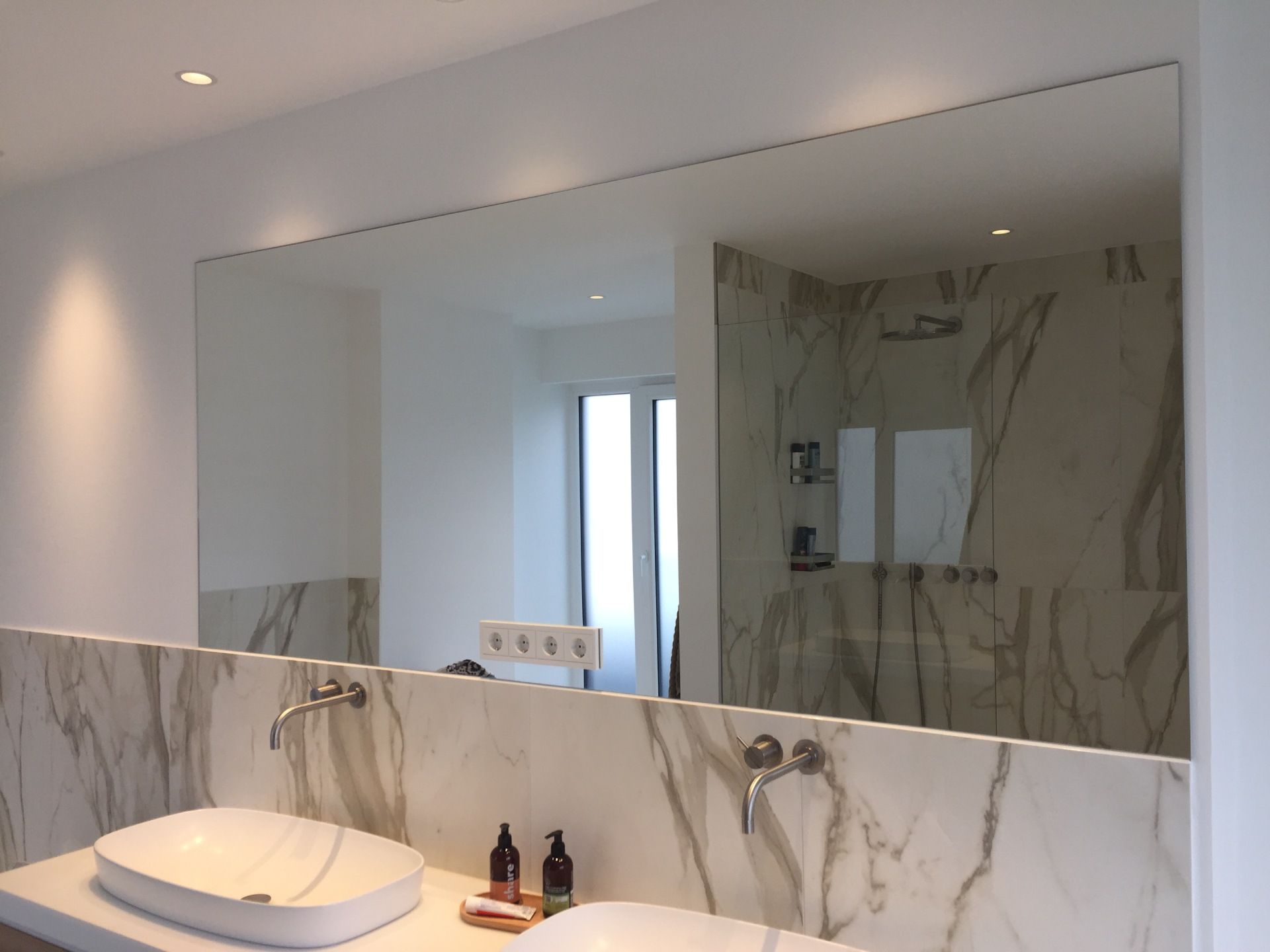 Ein Badezimmer mit Waschbecken und großem Spiegel